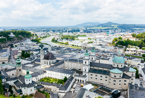 Salzburg, Austria - July 30, 2022: View of Historic City with the cathedral and mountains on cloudscape