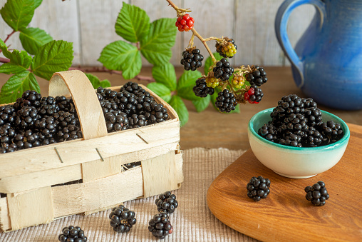 Metal bowl with frozen blueberries on rustic wooden table. Frozen berries.