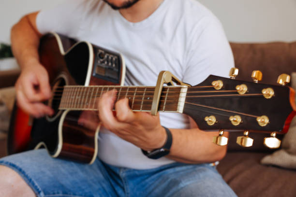istock Man effortlessly playing chords on acoustic guitar 1415371091
