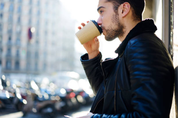 istock Man drinking takeaway coffee on street 1415372599