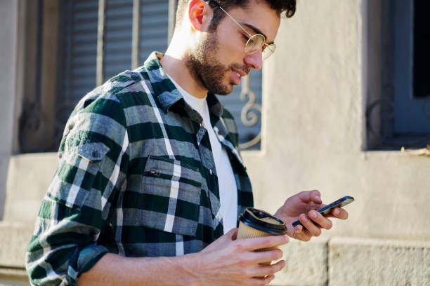 istock Crop ethnic man surfing internet on smartphone on street 1415372634