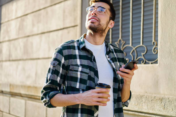 istock Young ethnic man enjoying coffee on street 1415372639