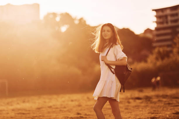 Having a walk. Young girl is on the field at sunny daytime having nice weekend.