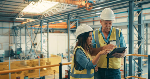 istock Distribution, inventory and logistics manager inspecting stock with employees on a tablet in the warehouse. Female worker discussing cargo with male supervisor before shipping the products out. 1415376508