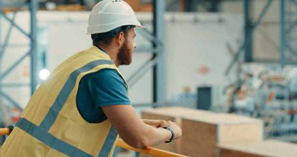 istock Thoughtful warehouse worker thinking while standing in a lift in a retail storeroom full of cargo goods. Young supervisor or engineer in a factory, stockroom or workshop looking at delivery shipment 1415378522