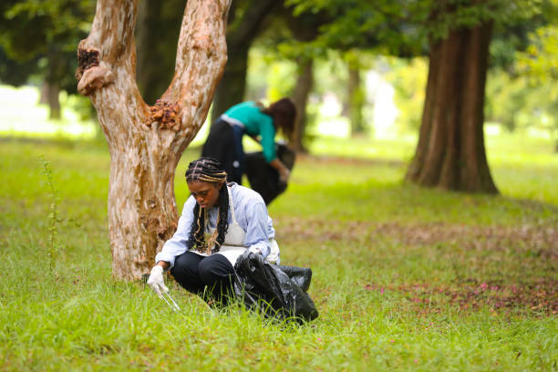 istock Black female engaging in community clean up 1415382340