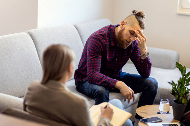 istock Young man talking to female psychologist during session. 1415382879