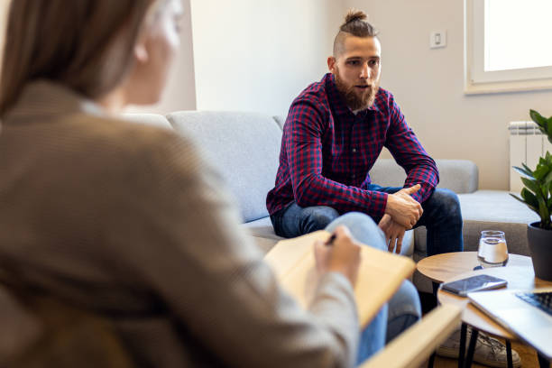 istock Young man talking to female psychologist during session. 1415383085