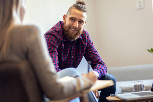 istock Young man talking to female psychologist during session. 1415383208
