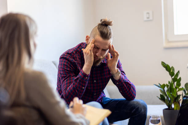 istock Young man talking to female psychologist during session. 1415383413