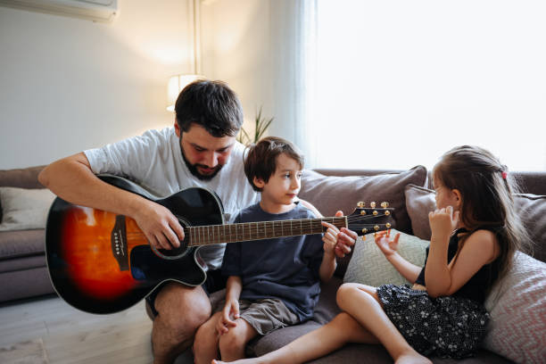 istock Father teaching his son and daughter guitar 1415384398