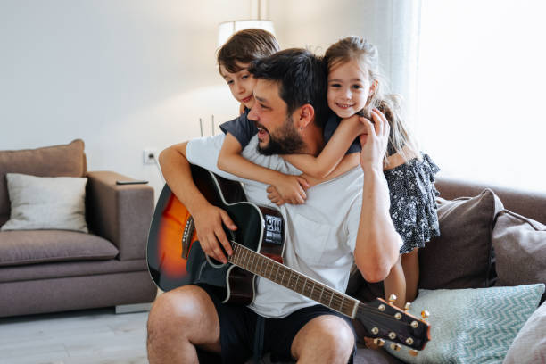 istock Father teaching his son and daughter guitar 1415384468