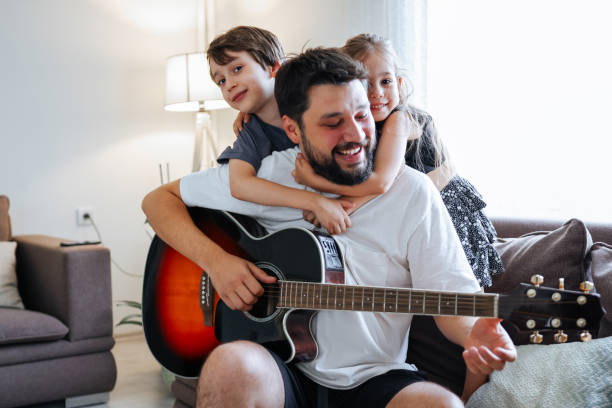 istock Father teaching his son and daughter guitar 1415384594