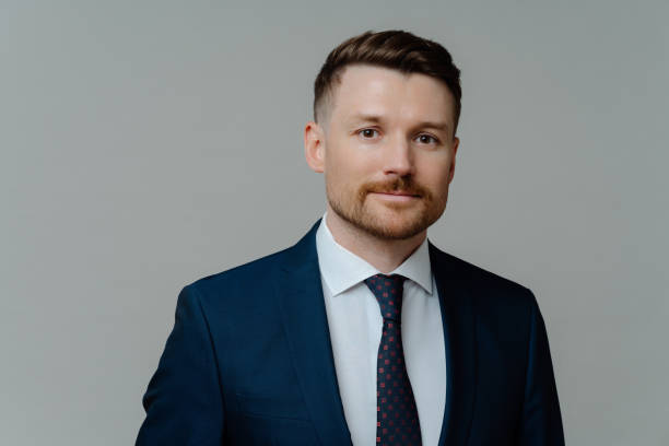 istock Young handsome male executive manager in elegant suit posing against grey background 1415386480