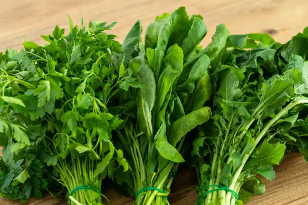 Close up photo of bunch of water cress or garden cress, parsley and arugula. Vegetarian diet or green nutrition concept.
