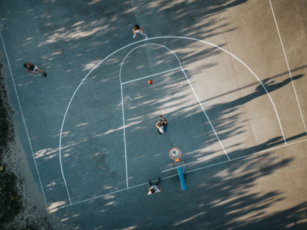 High angle view of friends playing basketball outdoors.