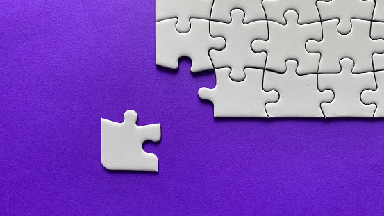 Jigsaw puzzle on purple background with customizable space for text or ideas. Copy space.