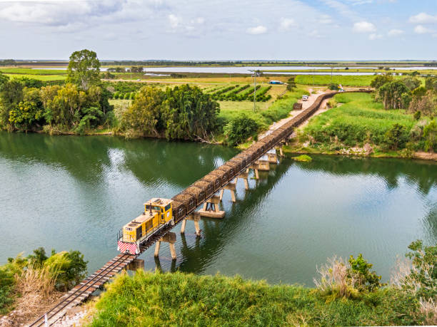 vista aérea cargada de tren de caña de azúcar que cruza el puente del río haughton cerca de giru qld - railway bridge fotografías e imágenes de stock