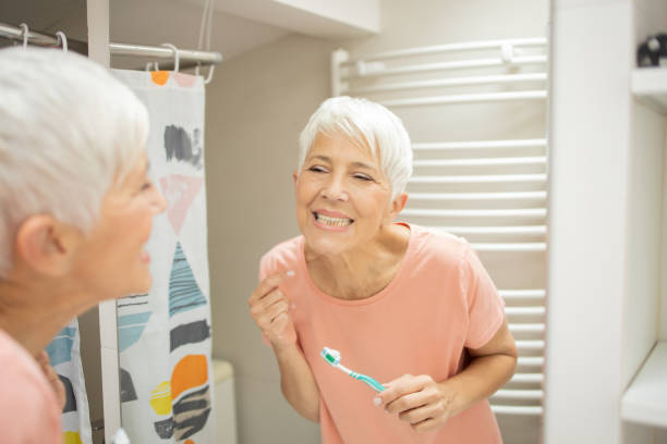 istock Senior woman brushing her teeth 1415389439