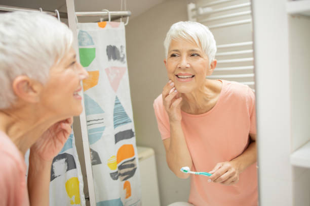 istock Senior woman brushing her teeth 1415389482