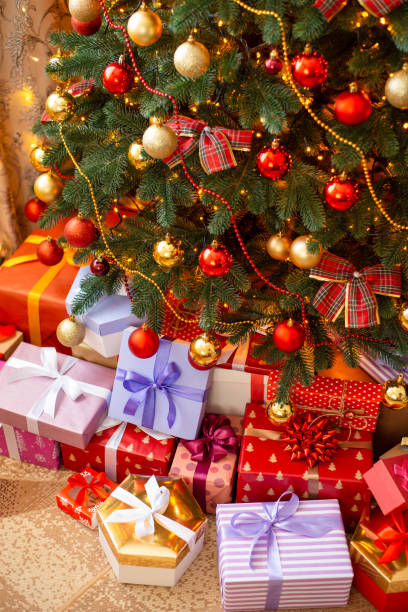 istock Decorated Christmas tree and colorful packed gift boxes under it, vertical photo 1415389747