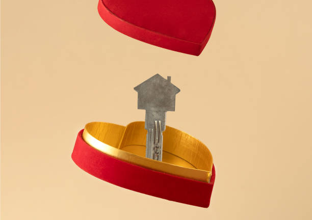 フローティングハート型のギフトボックスと家の形をしたドアキーのクローズアップ写真。