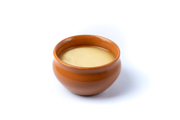 Pure cow ghee in ceramic bowl on white background Pure cow ghee in ceramic bowl on white background ghee stock pictures, royalty-free photos & images
