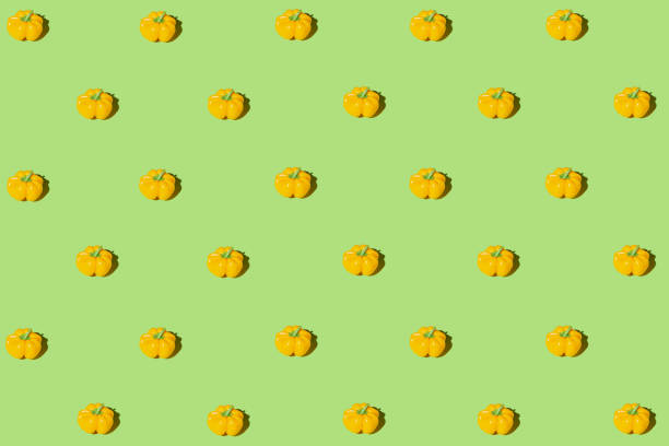istock Creative pattern made of yellow bell pepper on green pastel background with shadows. Minimal style. Healthy food ingredient concept 1415398704