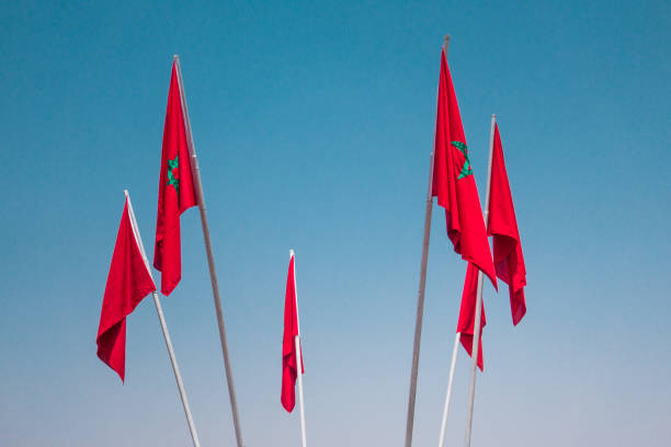 istock low angle view of moroccan flags against sky 1415399612