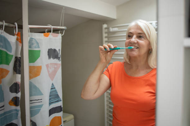 istock Senior woman brushing her teeth 1415402511