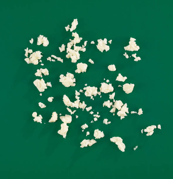 Crumbled cheese Crumbled cheese on green background feta cheese block stock pictures, royalty-free photos & images