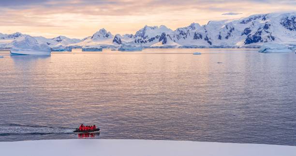 expéditions - zodiac navigue à travers le paysage d’icebergs de l’antarctique à portal point, situé à l’entrée de la baie de charlotte sur la péninsule de reclus, sur la côte ouest de la terre de graham. - iceberg antarctica glacier melting photos et images de collection