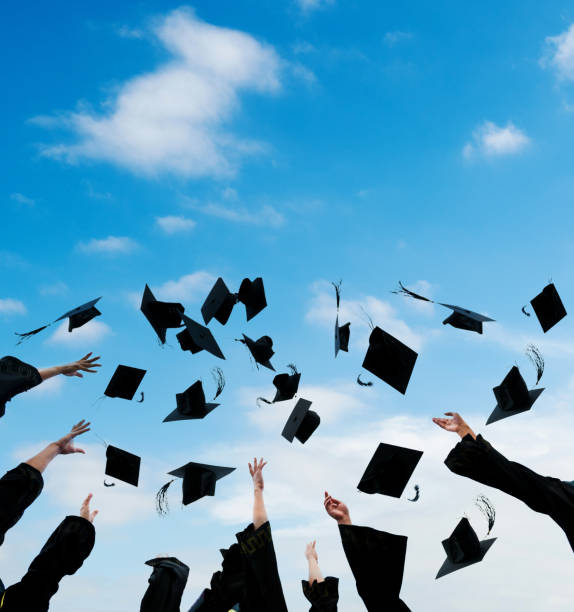 Excited group of college graduates throwing their hats in celebration