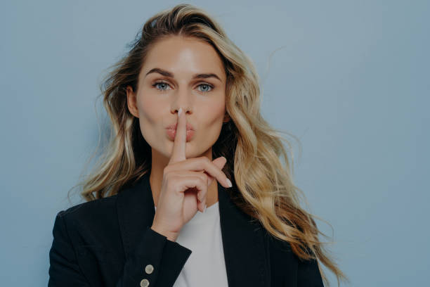 istock Blonde woman making shush gesture with her hand 1415405828