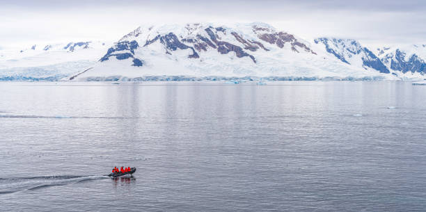 istock Expeditions - Zodiac cruises through Antarctic iceberg landscape at Portal Point which is located at the entrance to Charlotte Bay on the Reclus Peninsula, on the west coast of Graham Land. 1415406607