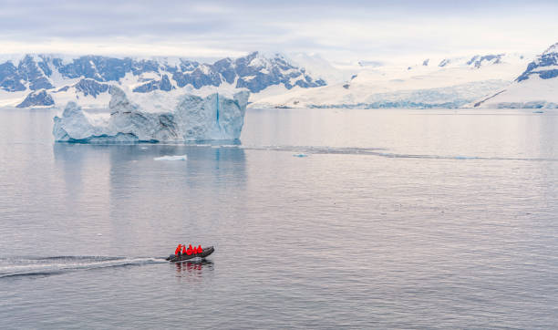 expeditionen - zodiac kreuzt durch die antarktische eisberglandschaft am portal point, der sich am eingang zur charlotte bay auf der reclus-halbinsel an der westküste von grahamland befindet. - us glacier national park stock-fotos und bilder