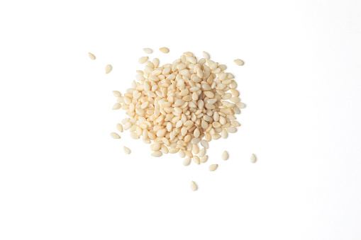 Top view of a heap of white sesame seeds on a white background