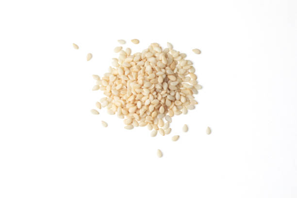 Top view of a heap of white sesame seeds Top view of a heap of white sesame seeds on a white background sesame stock pictures, royalty-free photos & images