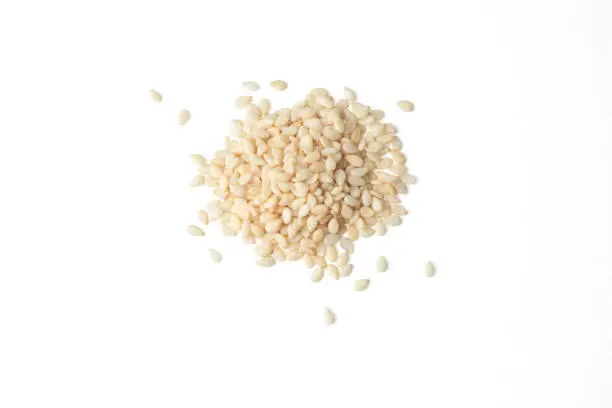 Top view of a heap of white sesame seeds on a white background