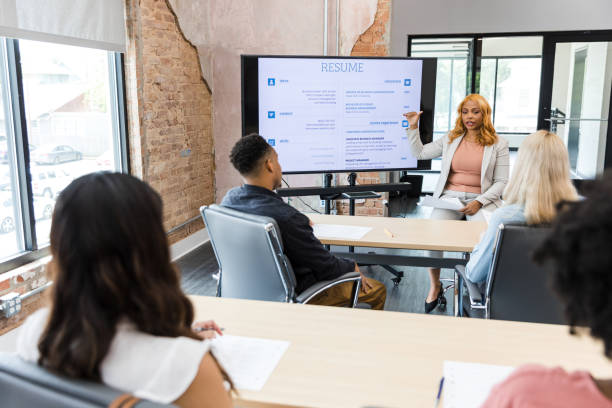 istock Female human resources representative teaches resume building seminar 1415407811