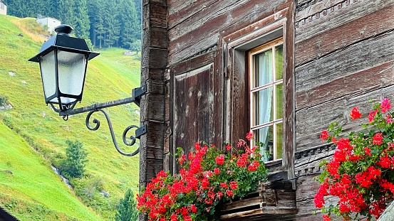 Mountain village house and a street lamp, seen in Vals, Graubunden