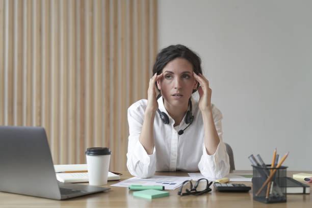 istock Frustrated businesswoman feeling tired while sitting in office, suffering from headache at work 1415410636