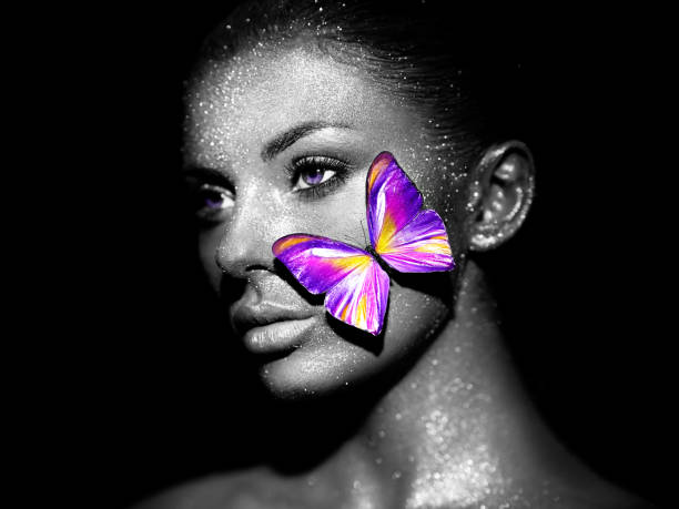 istock Beauty model woman with violet butterfly 1415411739