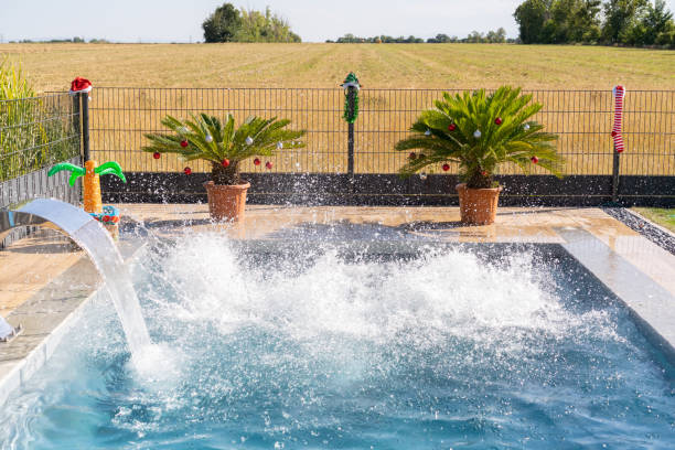 istock Empty pool with splashing water in private garden with christmas decoration 1415411973