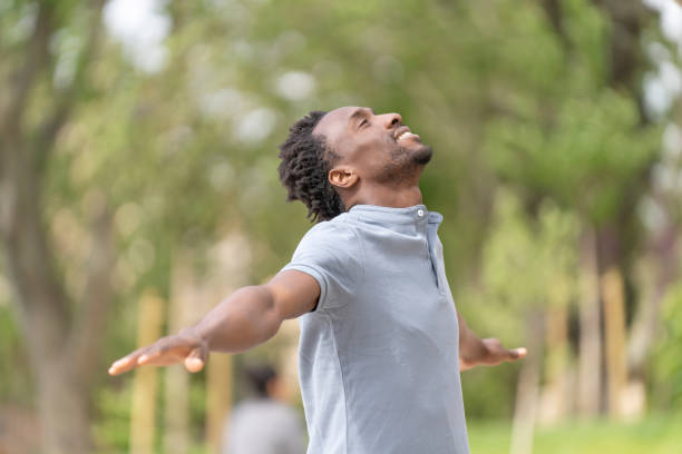 istock Black man with closed eyes and open arms 1415416987