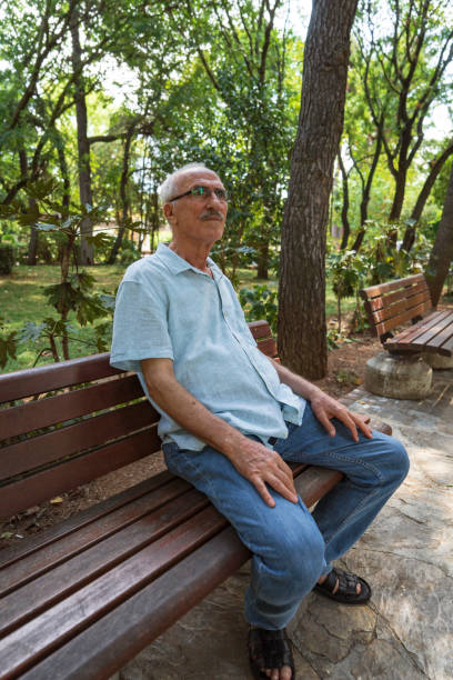istock Senior man relaxing at park bench 1415417208