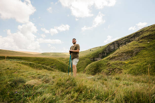 istock Man hikes along grassy mountain ridge at sunrise 1415418797