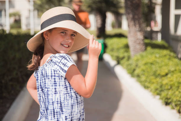 Travel, summer holidays, vacation and people concept.  Smiling happy girl in sun hat and sunglasses over blue sky background.