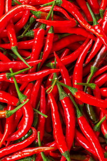 istock macro red chili background,Red hot chili peppers pattern Chili texture background. Close up landscape background of hot chili peppers. Roadside vegetable market. Red chili group. 1415422582
