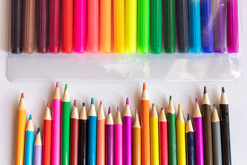 Colorful crayons sitting over blue background. Horizontal composition with copy space.